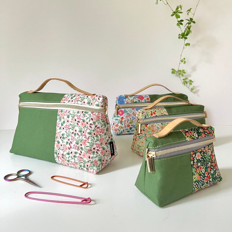 May include: Four green and floral patterned zippered pouches with gold hardware. The pouches are lined up on a white surface.