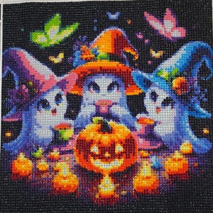 May include: Diamond art kit featuring three cartoon cats in witch hats, a jack-o'-lantern, and other Halloween-themed elements. The artwork is composed of small, colorful, square-shaped gems. The size of the artwork is 30 by 30 inches.