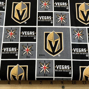 May include: Black and gray fabric with a repeating pattern of the Vegas Golden Knights hockey team logo. The logo features a gold knight's helmet with a V on the front, a star with two swords, and the words "Vegas Golden Knights".