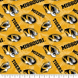 May include: Yellow fabric with a repeating pattern of black and gold tiger heads, the words "Missouri", "Mizzou", and "Tigers", and a black and gold tiger head inside an oval.