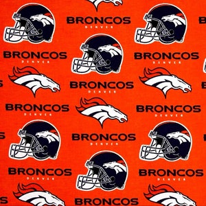 May include: Orange fabric with a repeating pattern of the Denver Broncos logo. The logo features a white bronco horse head with a blue and white helmet. The text "BRONCOS DENVER" is printed in white.