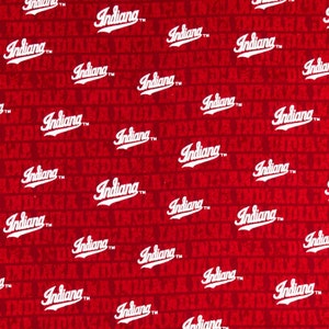 May include: Red fabric with a white repeated pattern of the word "Indiana" in a cursive font with a trademark symbol.