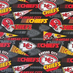 May include: Black fabric with a repeating pattern of red, yellow, and white Kansas City Chiefs logos. The logos include the team name, a red arrowhead, and the letters "KC".