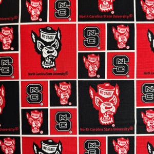 May include: A repeating pattern of red, black, and white squares featuring the North Carolina State University logo and the letter "S". The logo includes a wolf head and the text "NC STATE".