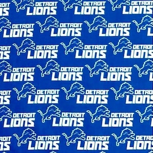 May include: A blue and white fabric with a repeating pattern of the Detroit Lions logo. The logo features a lion with a football in its mouth and the words "Detroit Lions".