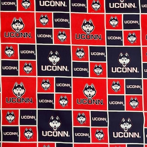 May include: A repeating pattern of red and navy blue squares featuring the word "UCONN" and a husky dog logo. The design is a repeating grid of squares, with the logo and text in white.
