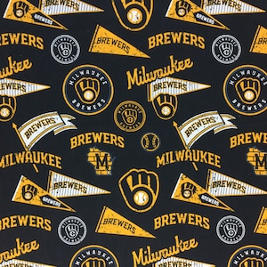 May include: A black fabric with a repeating pattern of yellow and white baseball-themed designs. The designs include the words "Brewers" and "Milwaukee", a baseball glove, a baseball, and a stylized logo of a baseball glove with the words "Milwaukee Brewers".