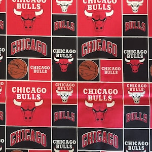 May include: Red and black fabric with a repeating pattern of the Chicago Bulls logo, a basketball, and the words "Chicago Bulls".