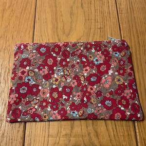 Pouch fabric with pink flowers on a dark beige background