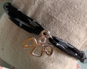 Children's bracelet mounted on a black ribbon with stars and its solid silver cherub charm