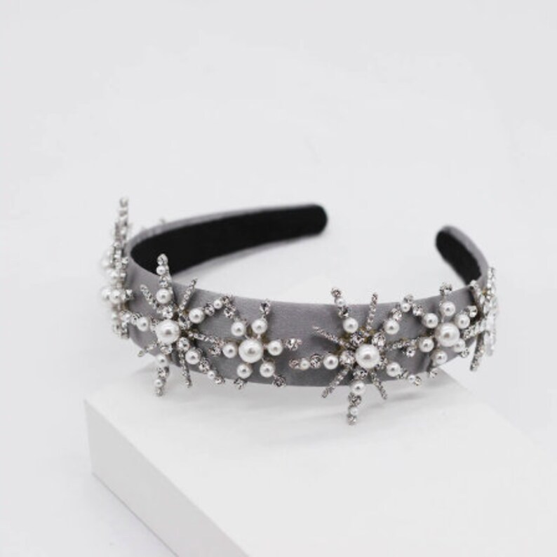 May include: A gray velvet headband with silver star-shaped embellishments and faux pearls.