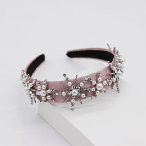 May include: A pink velvet headband with silver and pearl snowflake embellishments.
