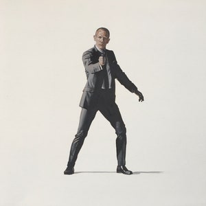 Puede incluir: Un hombre con un traje oscuro se para con el brazo derecho extendido, sosteniendo un arma de fuego, sobre un fondo blanco.