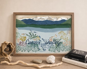 May include: A framed landscape print featuring the text Comox Valley, depicting blue mountains, a light blue body of water, green forest, and various shorebirds and aquatic plants in shades of green, yellow, and brown.