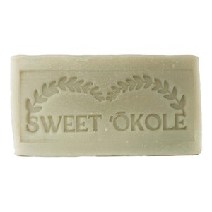 May include: A rectangular bar of soap with a green and white design. The soap has the words "SWEET ÖKOLE" embossed on it.