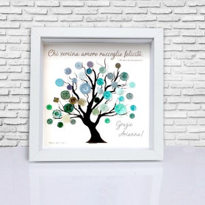 May include: A white framed picture with a black silhouette of a tree with blue, green, and brown buttons on the branches. The quote "Chi semina amore raccoglie felicita." is written on the top of the picture. The words "Grazie Arianna!" are written at the bottom of the picture.