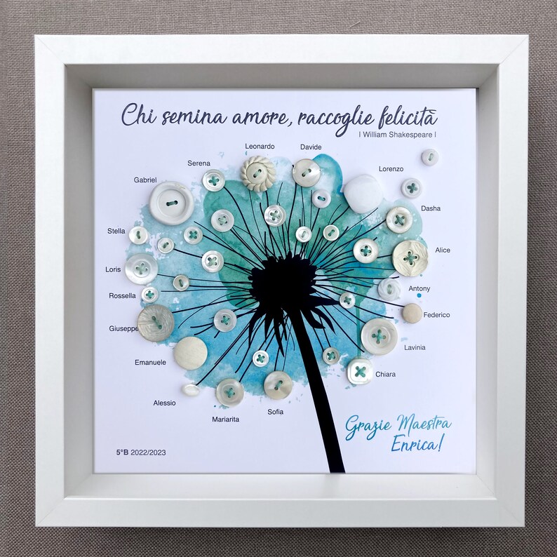 May include: A framed white and blue watercolour painting of a dandelion with white buttons attached to the dandelion's seeds. The buttons are labelled with names, and the quote "Chi semina amore, raccoglie felicita" is written at the top of the painting. The quote is attributed to William Shakespeare I. The painting also includes the text "Grazie Maestra Enrica!" and "5&deg;B 2022/2023".