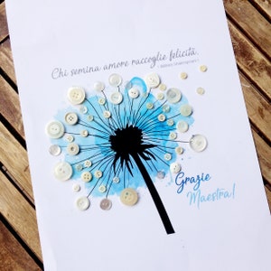 May include: A blue watercolour dandelion with white buttons for seeds. The quote "Chi semina amore raccoglie felicit&agrave;. - William Shakespeare" is written above the dandelion. The words "Grazie Maestra!" are written below the dandelion.