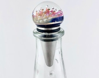 Tapón de botella de vidrio con trampa de burbujas sobre metal: soplado a mano, regalo único para amantes del vino.