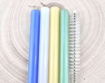 May include: Four glass drinking straws in blue, white, yellow, and green colours, with a cleaning brush.