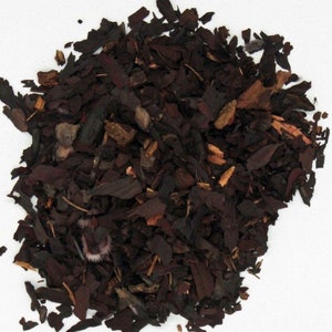 May include: A pile of dark brown cedar mulch. The mulch is made up of small, thin pieces of wood.