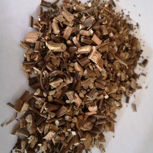 Op de afbeelding: Een hoop gedroogd, bruin en lichtbruin plantenmateriaal, waarschijnlijk kruiden of wortels, voor gebruik in kruidenremedies of thee.