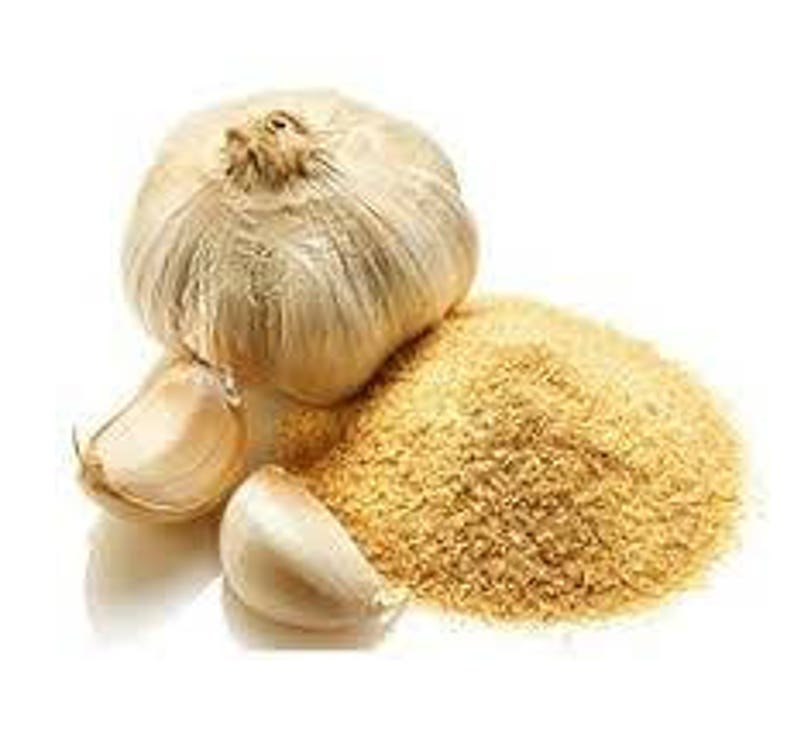 May include: A whole garlic bulb, two cloves, and a pile of granulated garlic sit on a white surface. The garlic bulb is off-white with a papery texture. The cloves are smooth and creamy. The granulated garlic is light brown.
