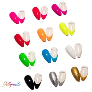 Pu&ograve; includere: Una collezione di unghie finte in vari colori, tra cui rosa, rosso, arancione, giallo, verde, blu, bianco, nero, argento e oro. Ogni unghia ha una punta trasparente e una base colorata. Il marchio "Jellynails" &egrave; visibile.