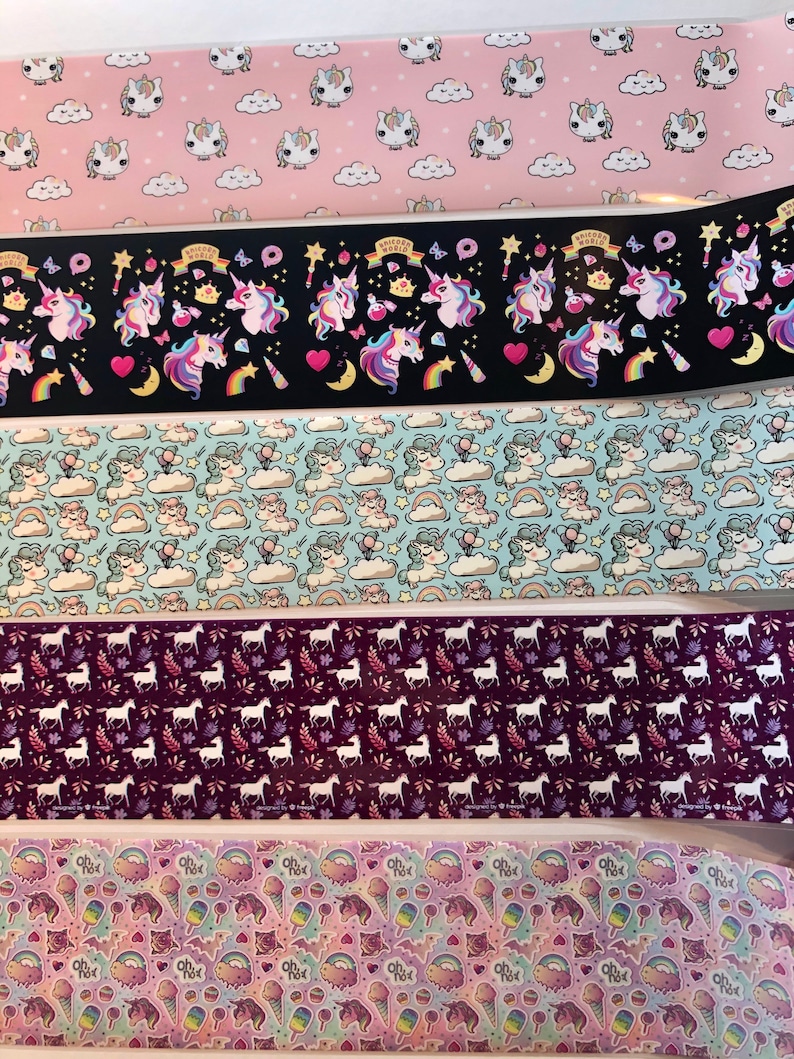 May include: Five different rolls of colourful patterned washi tape featuring unicorns, rainbows, clouds, stars, and hearts. The washi tape is perfect for adding a touch of whimsy to your crafts, journals, and planners.
