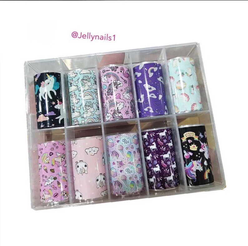 May include: A clear plastic box containing 10 rolls of nail art transfer foil. Each roll features a different unicorn-themed design with colours like pink, purple, blue, and black.