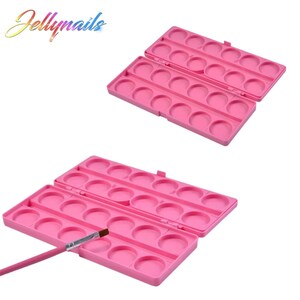 May include: Two open pink plastic palettes with multiple circular wells, ideal for holding nail art supplies. A pink handled brush is placed near one of the palettes. The word "Jellynails" is written in a colorful font in the upper left corner.