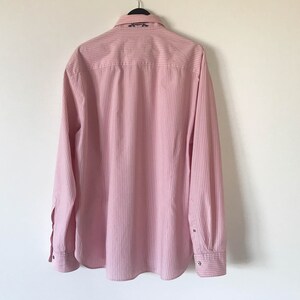 May include: A pink and white striped long-sleeve button-down shirt with a small embroidered design on the collar.