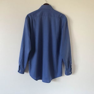 May include: A solid blue long-sleeved button-down shirt with a classic collar.