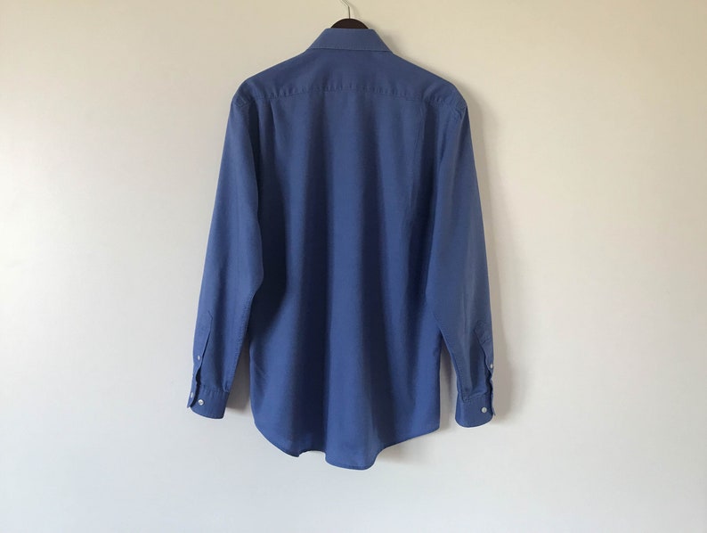 May include: A solid blue long-sleeved button-down shirt with a classic collar.