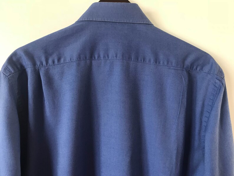 May include: A solid blue long-sleeved button-down shirt with a classic collar.