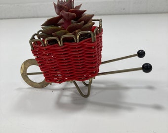 A small vintage wheelbarrow plant pot holder, ornament.
