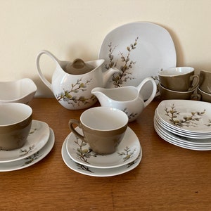 May include: A white tea set with a floral pattern. The set includes a teapot, creamer, sugar bowl, and six cups and saucers.