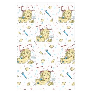 Op de afbeelding: Een witte achtergrond met een herhalend patroon van een cartoonvrouwenhoofd met blond haar, een microfoon en een blok Zwitserse kaas. De tekst "Taylor Swiss" wordt in het hele patroon herhaald.