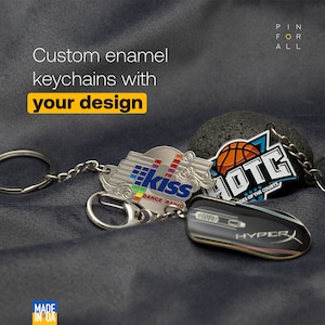 May include: A set of three custom enamel keychains with different designs. The keychains feature a basketball team logo, a radio station logo, and a computer mouse logo. The keychains are silver with colorful enamel details. The text "PIN FOR ALL" is visible in the top right corner of the image.