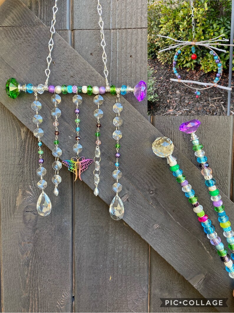 May include: A crystal suncatcher with a rainbow butterfly charm, featuring a beaded bar with green, purple, and white beads, and crystal teardrop prisms hanging from it.