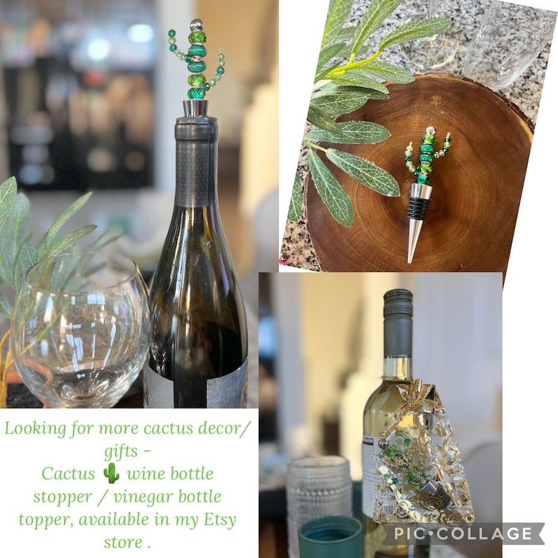 May include: Two green glass cactus bottle stoppers. One is on a wine bottle, the other is on a wooden surface. The caption reads "Looking for more cactus decor/gifts - Cactus wine bottle stopper/vinegar bottle topper, available in my Etsy store."