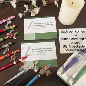 May include: A set of eight colorful pens with decorative charms and beads. Each pen comes with a printed card and a foil pouch. The card has the quote "When writing the story of your life, don't let anyone else hold your pen. Write well, Edit often!"