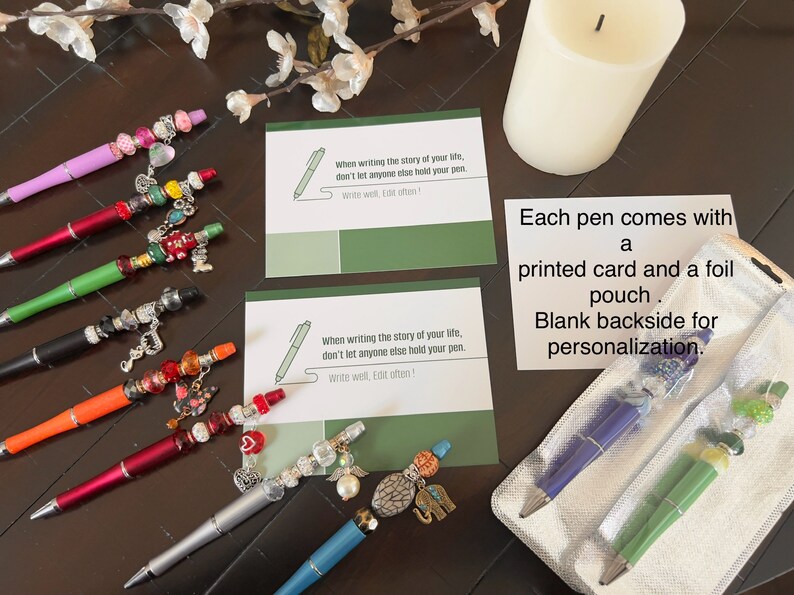 May include: A set of eight colorful pens with decorative charms and beads. Each pen comes with a printed card and a foil pouch. The card has the quote "When writing the story of your life, don't let anyone else hold your pen. Write well, Edit often!"