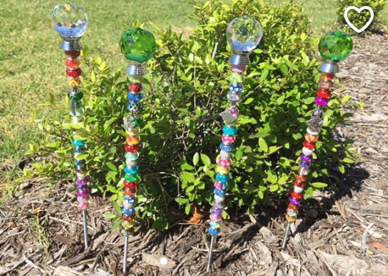 May include: Four colorful garden stakes with crystal tops. Each stake is decorated with beads in various colors, including pink, blue, green, red, and purple.