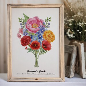 Puede incluir: Una lámina enmarcada con un ramo de flores en acuarela de colores rosa, rojo, naranja y azul. Debajo de la ilustración floral, el texto dice "Grandma's Bunch" seguido de los nombres Corrine, David, William, Alexander, Chris, Helen, Jack & Nancy.