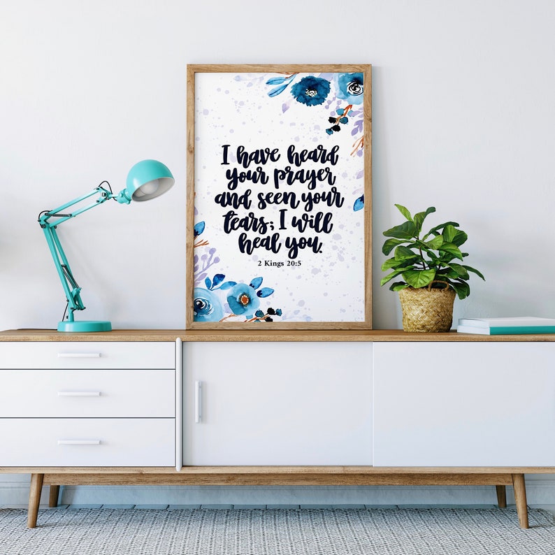 May include: A framed print with a white background and blue watercolor flowers. The print features the Bible verse "I have heard your prayer and seen your tears; I will heal you." from 2 Kings 20:5.