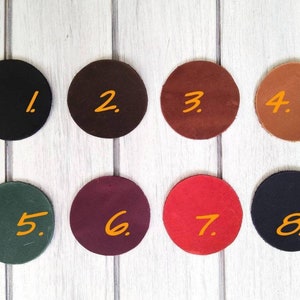 May include: Eight round leather swatches in different colors, numbered 1 through 8. The swatches are arranged in two rows of four.