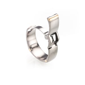 Op de afbeelding: Een zilveren ring met een gouden accent op de sluiting. De ring is open en de sluiting is zichtbaar.
