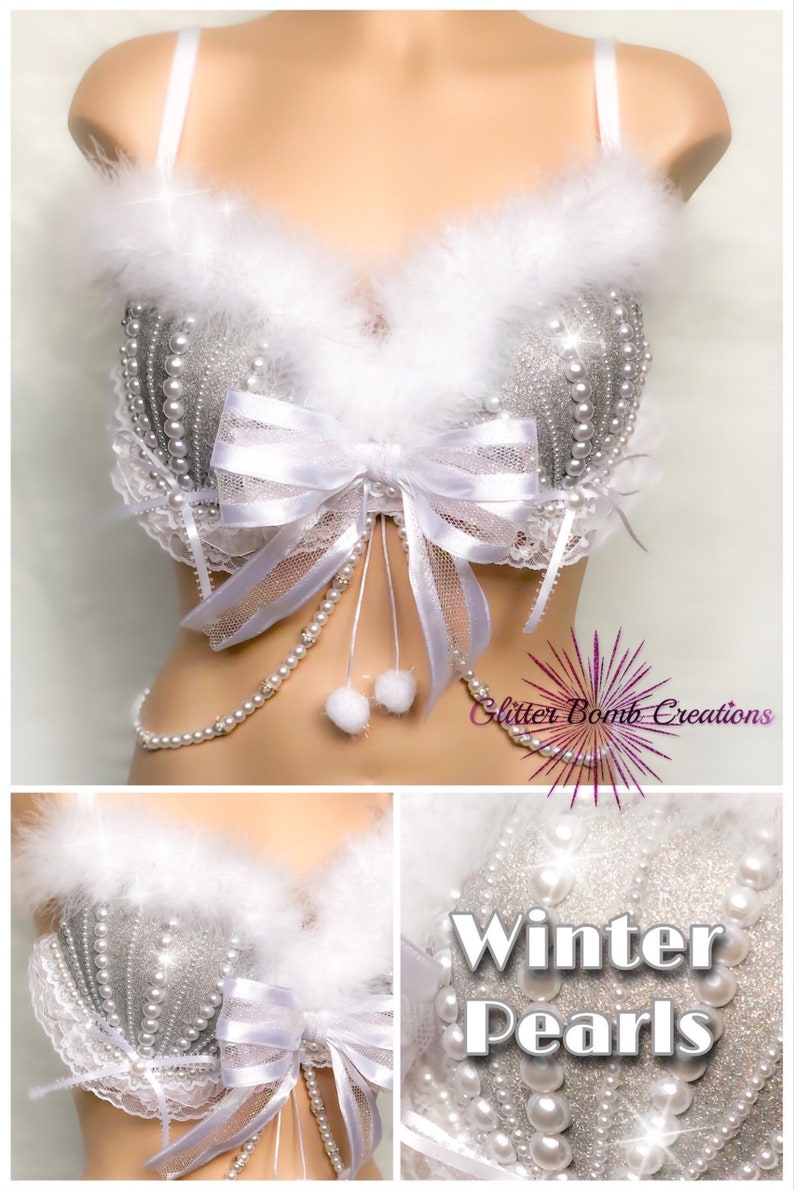 Pu&ograve; includere: Un reggiseno bianco con paillettes argentate e decorazioni di perle. Il reggiseno ha un bordo in pelliccia bianca e un fiocco di raso bianco. Il reggiseno &egrave; etichettato "Winter Pearls".