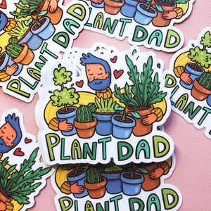 May include: A set of five stickers featuring a cartoon character with a beard and a variety of potted plants. The stickers are all white with a yellow background and the text "Plant Dad" in green and blue letters.